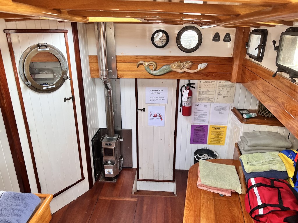 Below deck, the door on the left is the bathroom. On the right is a bunk and behind me was a table